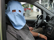 Der verdchtige Mann mit seiner Kopfhaube mit Sehschlitzen auf dem Beifahrersitz des gesuchten Autos