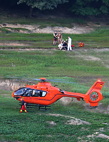 Landeplatz des Hubschraubers an einem Hang am Rand der Talsperre, oberhalb davon die Einsatzstelle mit Rettungskrften und dem Patienten
