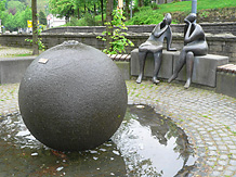 Die Skulpturengruppe hinter einem benachbarten Brunnen